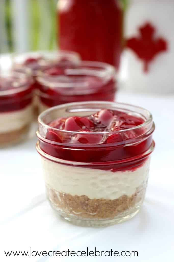 These mini cherry cheesecake treats served in mason jars are colorful and easy to eat. 