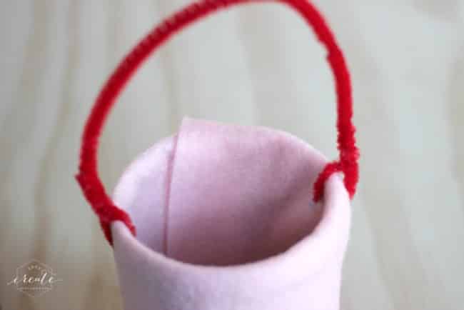 Attach the pipe cleaner through the drill holes and twist the ends to create the handle