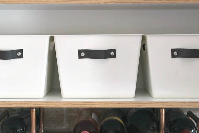 Turn any dollar store bin into DIY stylish organization totes with spray paint and leather handles. Perfect for the kitchen, bedroom or linen closet! 