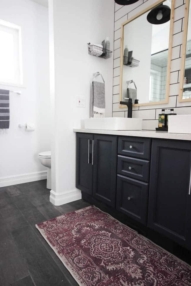 A beautiful modern bathroom renovation with chrome and matte black faucets, sleek modern fixtures and natural wood accents. Beautiful transformation!