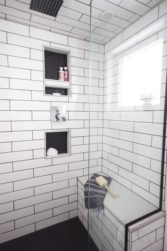 A beautiful modern bathroom renovation with chrome and matte black faucets, sleek modern fixtures and natural wood accents. Beautiful transformation!