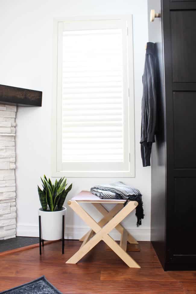 A beautiful Modern Master Bedroom Renovation Reveal! Gorgeous bold wallpaper, black, white and grey tones alongside wooden accent furniture. Ikea cabinets with a sliding barn door. And a white brick fireplace with a dark wooden mantel. Touches of blue and deep red finish the space perfectly. Beautiful transformation! 