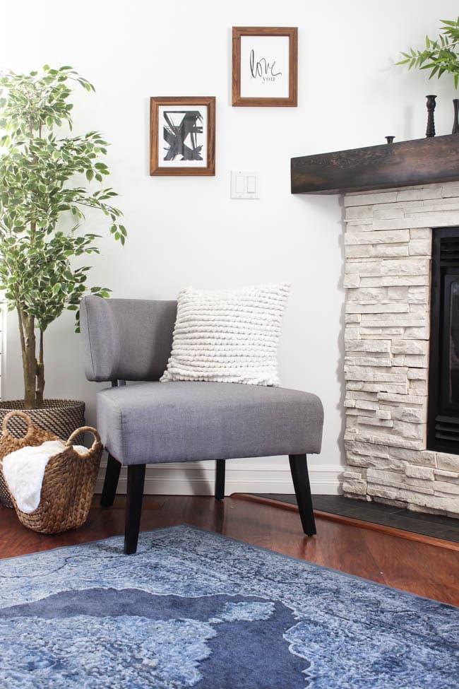 A beautiful Modern Master Bedroom Renovation Reveal! Gorgeous bold wallpaper, black, white and grey tones alongside wooden accent furniture. Ikea cabinets with a sliding barn door. And a white brick fireplace with a dark wooden mantel. Touches of blue and deep red finish the space perfectly. Beautiful transformation! 