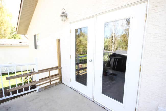 A stunning backyard makeover inspired completed with Behr paints. Love the bright painted blue doors, and the grey outdoor sectional. Brighten up your boring patio in no time! Beautiful DIY pallet side tables, and black and white accessories complete the space. Summer is here! 