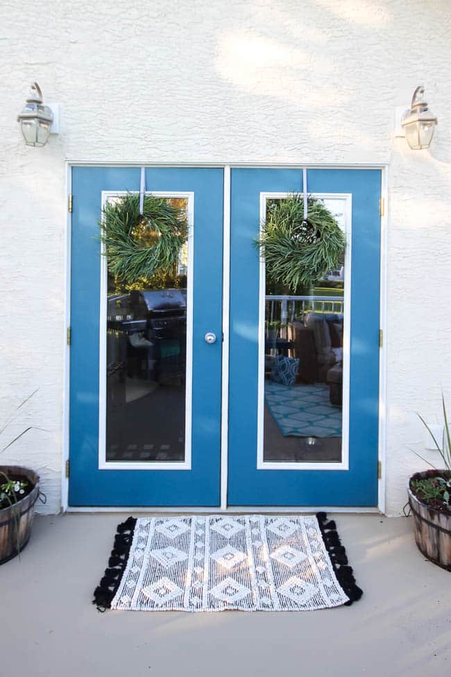 A stunning backyard makeover inspired completed with Behr paints. Love the bright painted blue doors, and the grey outdoor sectional. Beautiful DIY pallet side tables, and black and white accessories complete the space. Summer is here! 