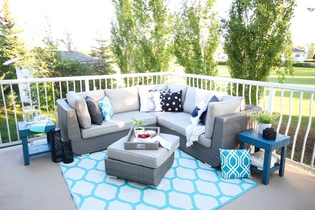 A stunning backyard makeover inspired completed with Behr paints. Love the bright painted blue doors, and the grey outdoor sectional. Beautiful DIY pallet side tables, and black and white accessories complete the space. Summer is here! 
