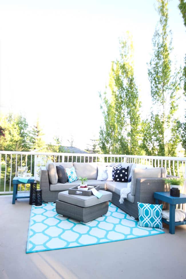 A stunning backyard makeover inspired completed with Behr paints. Love the bright painted blue doors, and the grey outdoor sectional. Beautiful DIY pallet side tables, and black and white accessories complete the space. Summer is here! 