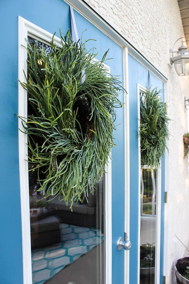 A stunning backyard makeover inspired completed with Behr paints. Love the bright painted blue doors, and the grey outdoor sectional. Beautiful DIY pallet side tables, and black and white accessories complete the space. Summer is here!