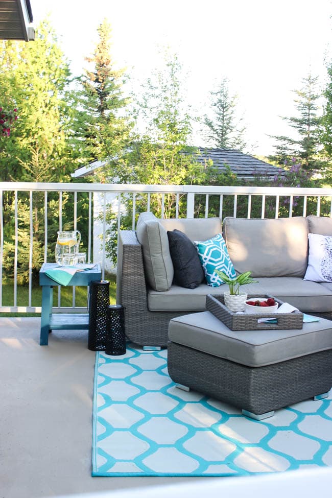 A stunning backyard makeover inspired completed with Behr paints. Love the bright painted blue doors, and the grey outdoor sectional. Beautiful DIY pallet side tables, and black and white accessories complete the space. Summer is here! 