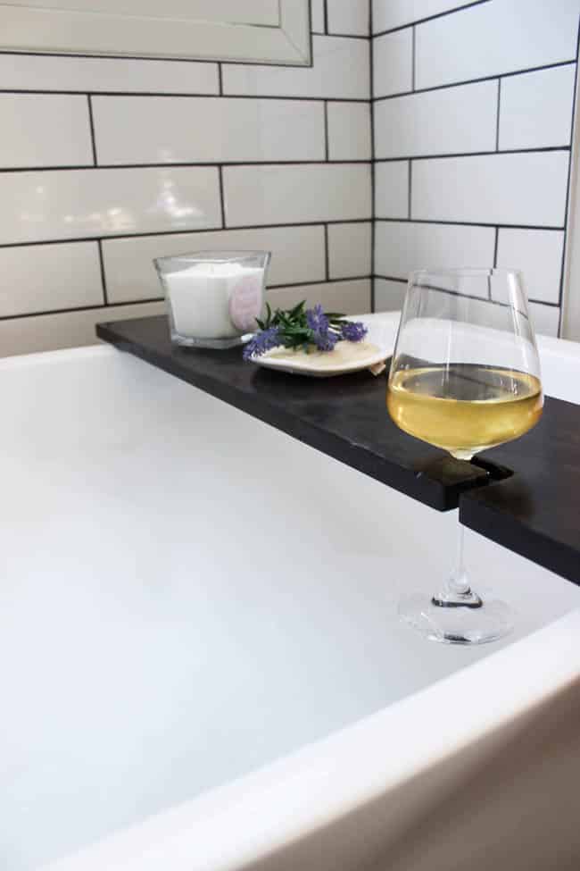 Build your own DIY Bath Table with this simple tutorial! Bath trays are the perfect bathroom accessories to add character and style! Love that this bathtub tray has a wine glass holder too!