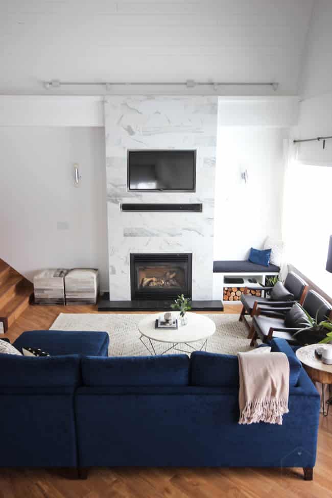 This gorgeous Modern Living Room reveal is finally here! This space came a long way from an outdated, empty space in this beautiful barn home. Love all of the contemporary DIY and decor ideas in this beautiful living space! The tiled fireplace and blue couch are stunning!