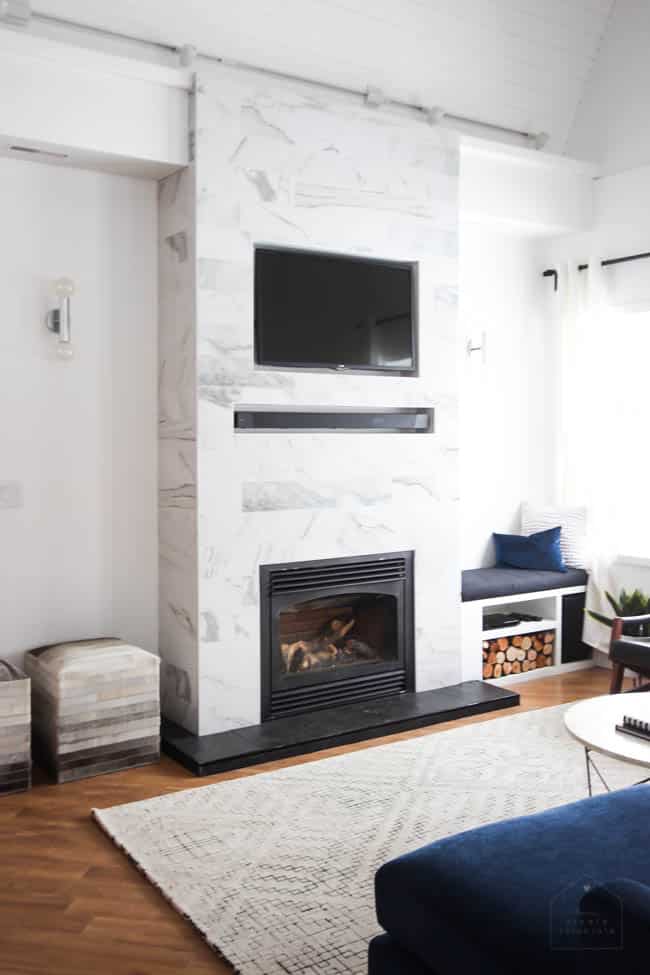 This gorgeous Modern Living Room reveal is finally here! This space came a long way from an outdated, empty space in this beautiful barn home. Love all of the contemporary DIY and decor ideas in this beautiful living space! The tiled fireplace and blue couch are stunning!