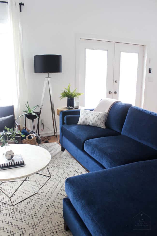 This gorgeous Modern Living Room reveal is finally here! This space came a long way from an outdated, empty space in this beautiful barn home. Love all of the contemporary DIY and decor ideas in this beautiful living space! The tiled fireplace and blue couch are stunning!