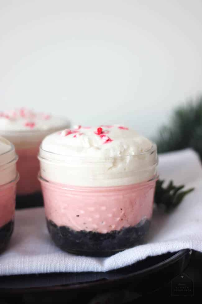No bake candy cane cheesecake desserts in small glass jars.