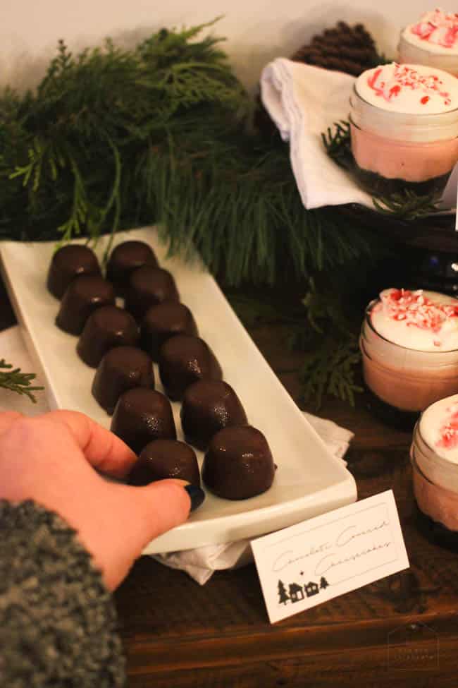 Reaching for miniature chocolate covered cheesecakes.