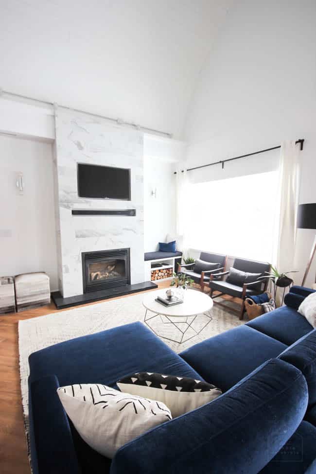 This gorgeous Modern Living Room reveal is finally here! This space came a long way from an outdated, empty space in this beautiful barn home. Love all of the contemporary DIY and decor ideas in this beautiful living space! The tiled fireplace and blue couch are stunning!