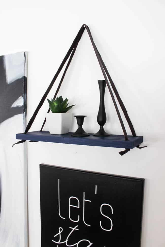 Love this simple modern shelf idea! This simple DIY hanging shelf makes the perfect wall art. If you have some scrap wood and leather you can make this floating shelf in no time! 