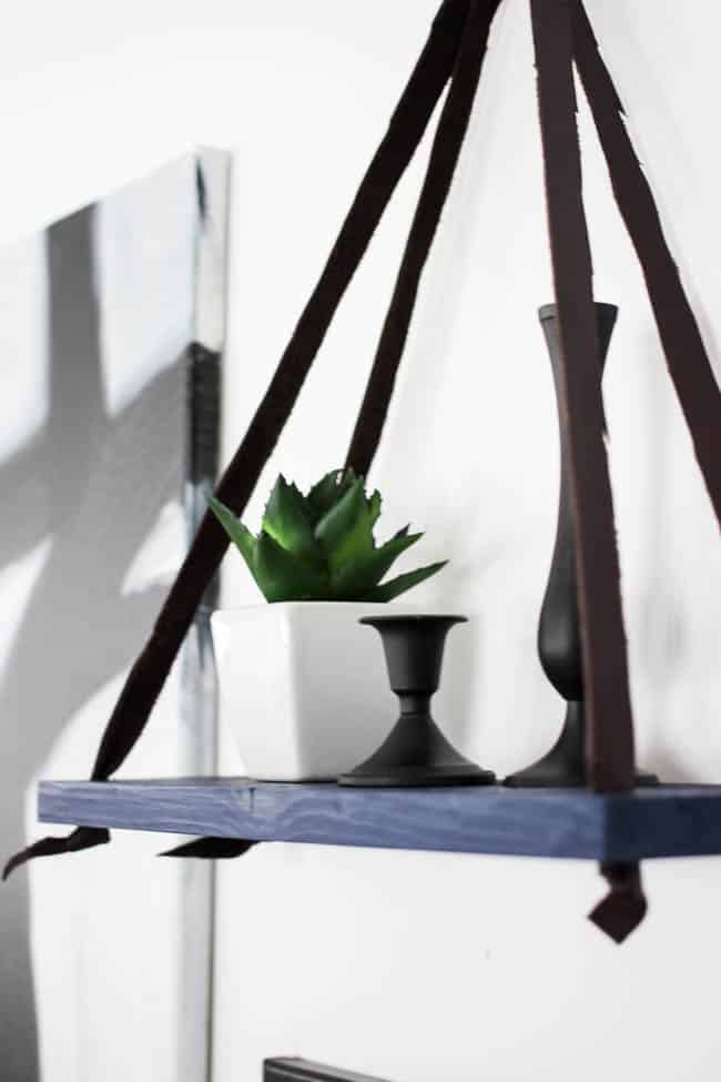 Love this simple modern shelf idea! This simple DIY hanging shelf makes the perfect wall art. If you have some scrap wood and leather you can make this floating shelf in no time!