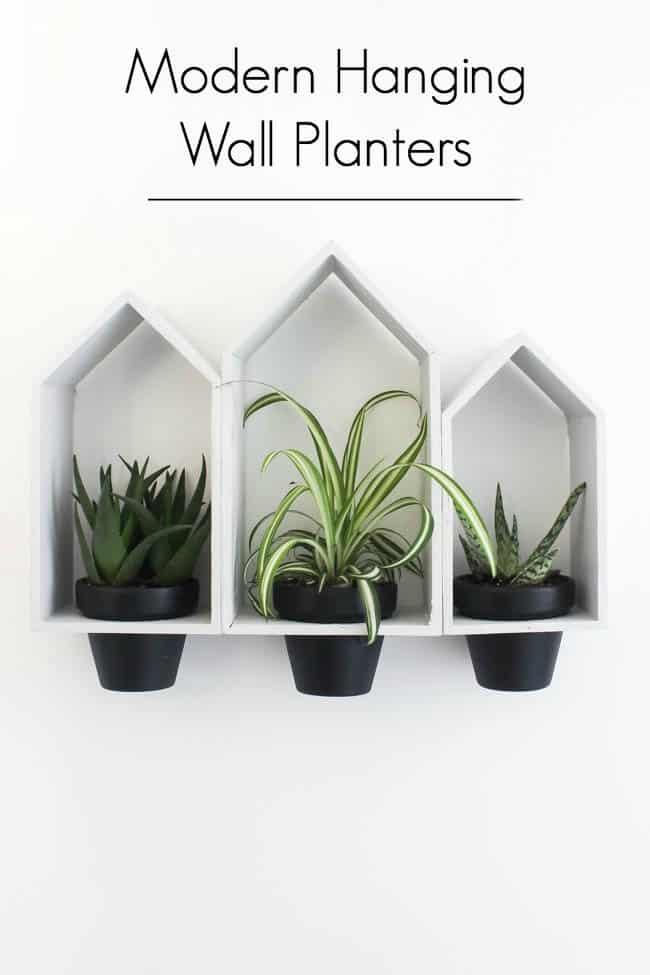 Beautiful Hanging Wall Planters to bring some greenery into your home! Love the modern look of these planters, and the dollar store price tag! Buy the terra cotta pots and wooden houses from the dollar store!