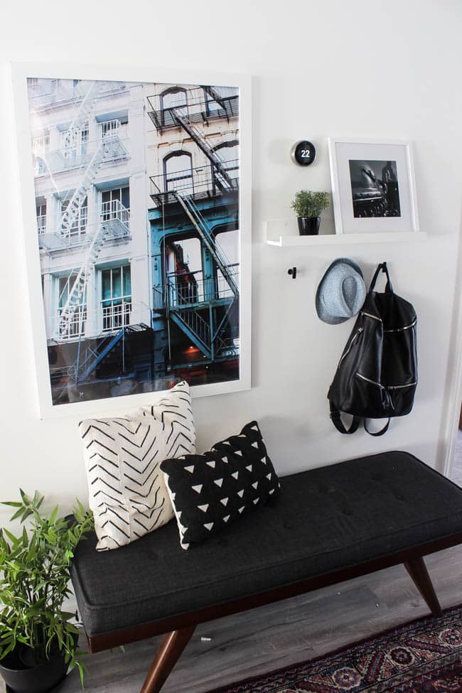 Beautiful hallway decor ideas! Love the eclectic mix of materials and styles in this space. Beautiful light flooring, gorgeous overlapping barn doors, modern artwork, and a vintage hallway runner complete the space. Perfect ideas to fill up a wide hallway!