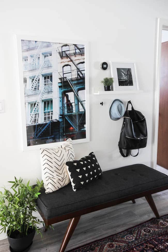 Beautiful hallway decor ideas! Love the eclectic mix of materials and styles in this space. Beautiful light flooring, gorgeous overlapping barn doors, modern artwork, and a vintage hallway runner complete the space. Perfect ideas to fill up a wide hallway!