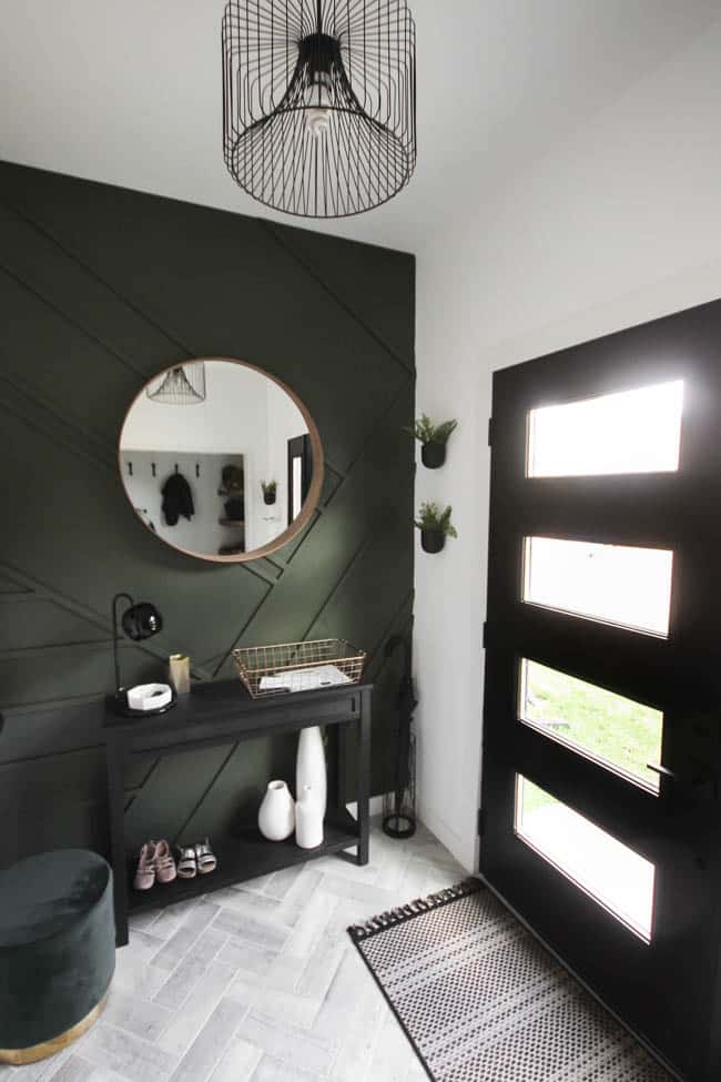 This gorgeous modern entryway reveal is here! What a huge transformation from the outdated space it once was! From the beautiful bench, to the herringbone floors, to the black front door, and the wood accent feature wall. This entry is stunning!