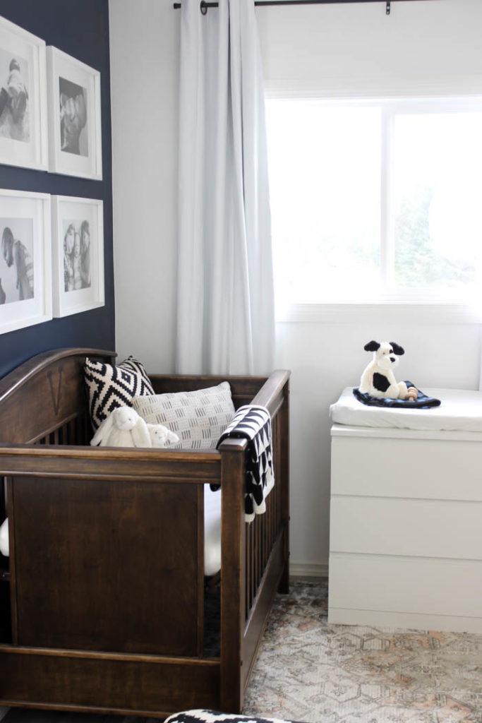 Beautiful ideas for a small modern nursery! This tiny baby room is off to the side of the master bedroom. Love the simple decor, from the navy wall to the brown crib and the beautiful gallery wall!