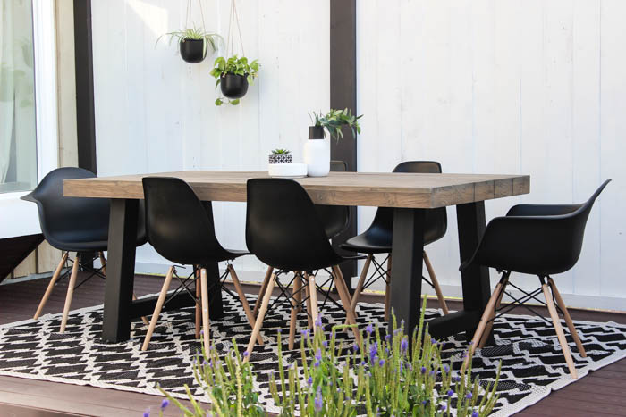 Wow! A beautiful modern outdoor space! The modern table from Article is a stunning addition to this outdoor deck. Finished off with a stunning black and white privacy wall and the gorgeous string lighting! 