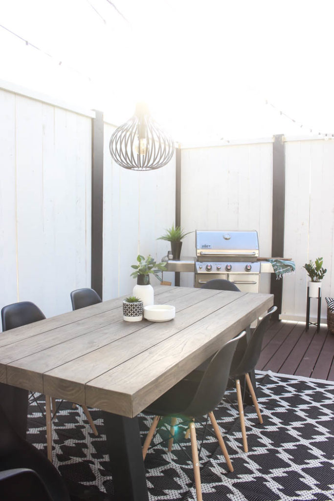 Wow! A beautiful modern outdoor space! The modern table from Article is a stunning addition to this outdoor deck. Finished off with a stunning black and white privacy wall and the gorgeous string lighting! 