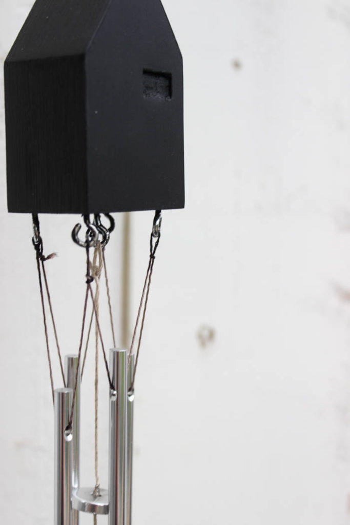 Beautiful modern wind chimes! Add beautiful decor to your outdoor space or deck with this simple thrift store update! Love the miniature houses and the stylish new take on wind chimes! 