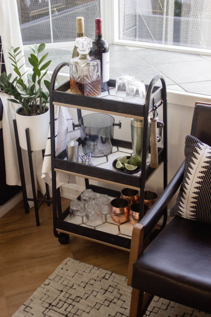 This modern bar cart is stunning! It's hard to believe that this is a DIY! Love the tile inlays and the mix of black, white, and gold in the design. Beautiful bar cart styling and ideas for your home entertaining! #DIY #barcart #tile #luxe #modern