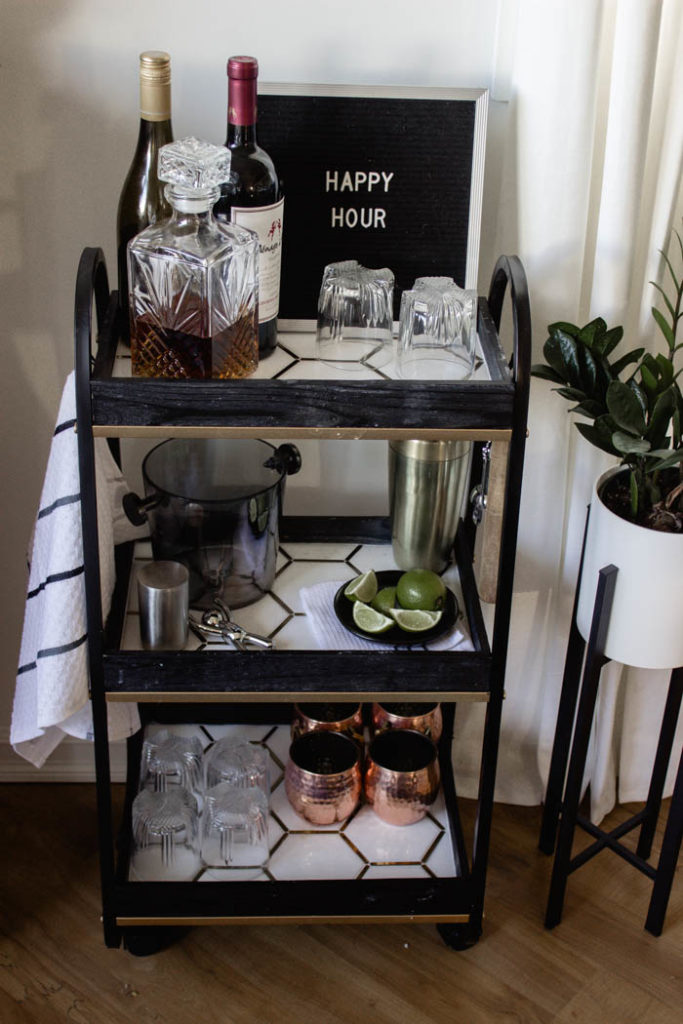 This modern bar cart is stunning! It's hard to believe that this is a DIY! Love the tile inlays and the mix of black, white, and gold in the design. Beautiful bar cart styling and ideas for your home entertaining! #DIY #barcart #tile #luxe #modern