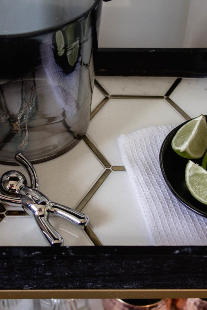 This modern bar cart is stunning! It's hard to believe that this is a DIY! Love the tile inlays and the mix of black, white, and gold in the design. Beautiful bar cart styling and ideas for your home entertaining! #DIY #barcart #tile #luxe #modern