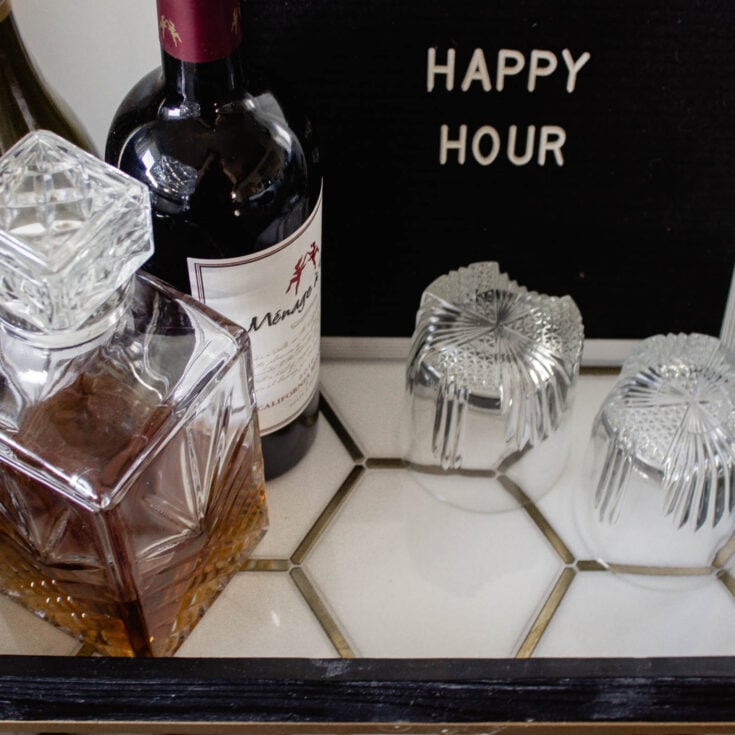 This modern bar cart is stunning! It's hard to believe that this is a DIY! Love the tile inlays and the mix of black, white, and gold in the design. Beautiful bar cart styling and ideas for your home entertaining! #DIY #barcart #tile #luxe #modern