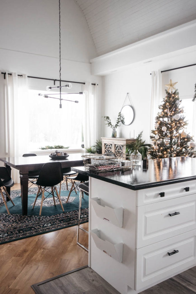 A Modern Minimalist Christmas Kitchen and Dining Room! LOVE the subtle touches of Christmas and the beautiful decor in these two rooms. A beautiful mix of natural colours in the green, black, and white colour palette. Touches of nordic and scandi style in this minimalistic holiday design. #nordic #modern #Christmas #Christmasdecor #ChristmasKitchen #blackandwhite 