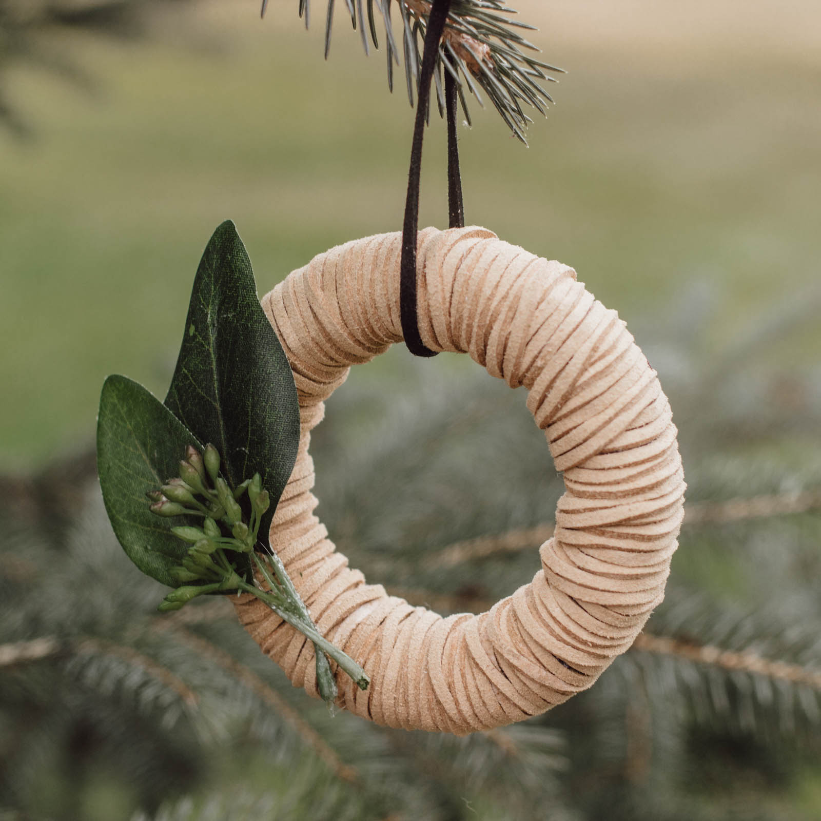 Beautiful mini wreath ornaments! These stylish leather ornaments are the perfect holiday accessory! Decorate your tree with this simple DIY Christmas craft! Perfect for modern, farmhouse, traditional, or any decor style! #Christmascraft #christmas #modernChristmas #holidaydecor #wreath