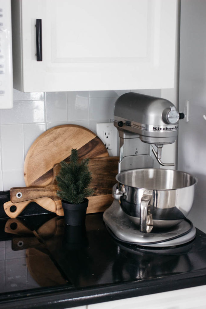 A Modern Minimalist Christmas Kitchen and Dining Room! LOVE the subtle touches of Christmas and the beautiful decor in these two rooms. A beautiful mix of natural colours in the green, black, and white colour palette. Touches of nordic and scandi style in this minimalistic holiday design. #nordic #modern #Christmas #Christmasdecor #ChristmasKitchen #blackandwhite 