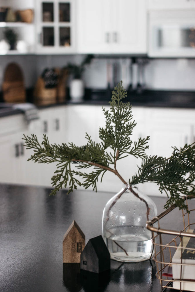 A Modern Minimalist Christmas Kitchen and Dining Room! LOVE the subtle touches of Christmas and the beautiful decor in these two rooms. A beautiful mix of natural colours in the green, black, and white colour palette. Touches of nordic and scandi style in this minimalistic holiday design. #nordic #modern #Christmas #Christmasdecor #ChristmasKitchen #blackandwhite