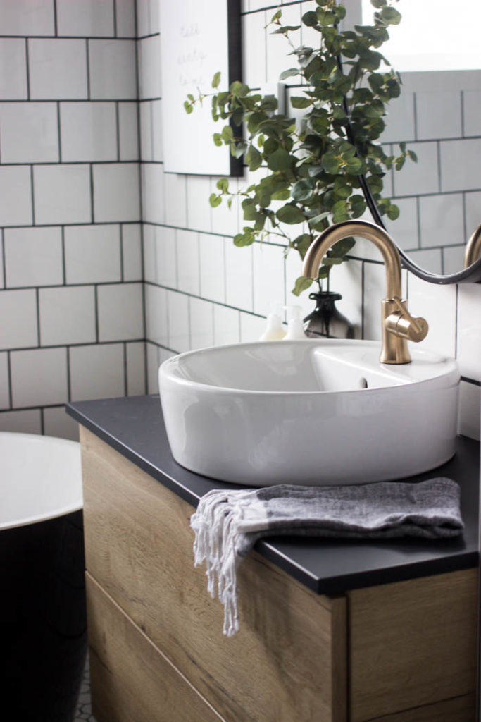 Wow! This modern Bathroom Reveal is absolutely stunning! What a gorgeous space! Everything from the black tub and shower frame, the champagne bronze faucets, and the wood vanity to the black ceiling and built-in storage units! What an incredible transformation! #modernbathroom #paintedceiling #blackceiling #blackandwhite #bathroom #remodel #renovations