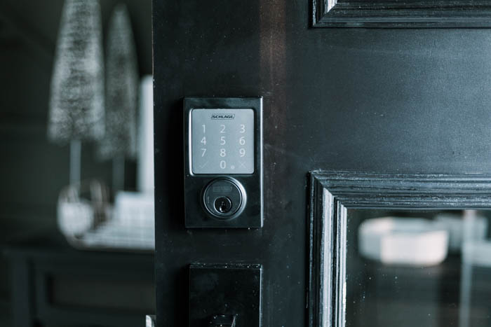 Update your front door with a keyless door lock. These amazing smart locks can be controlled with an app and linked to your Google Home device. Love the matte black lock and hardware on this black door! #smarttechnology #entry #modernentry #keylessentry #hardware