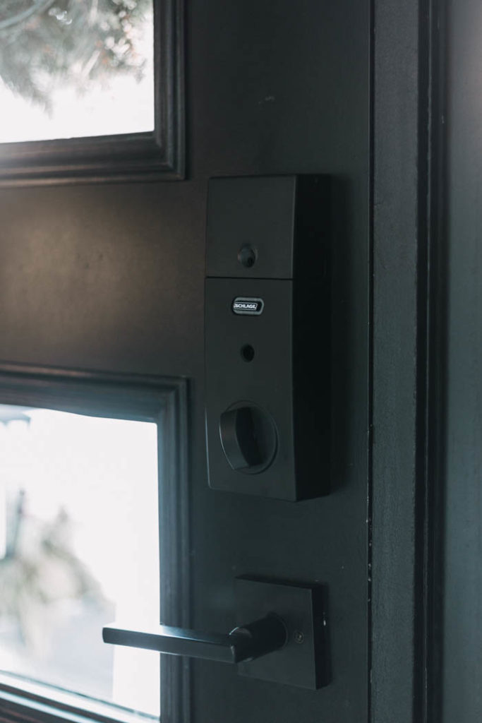 Update your front door with a keyless door lock. These amazing smart locks can be controlled with an app and linked to your Google Home device. Love the matte black lock and hardware on this black door! #smarttechnology #entry #modernentry #keylessentry #hardware