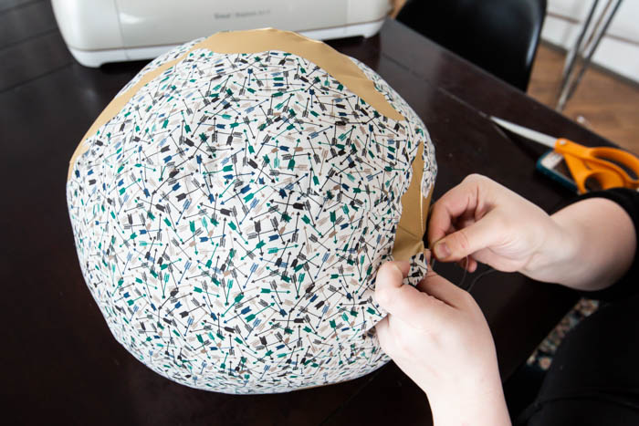 hand stitching a fabric ball together