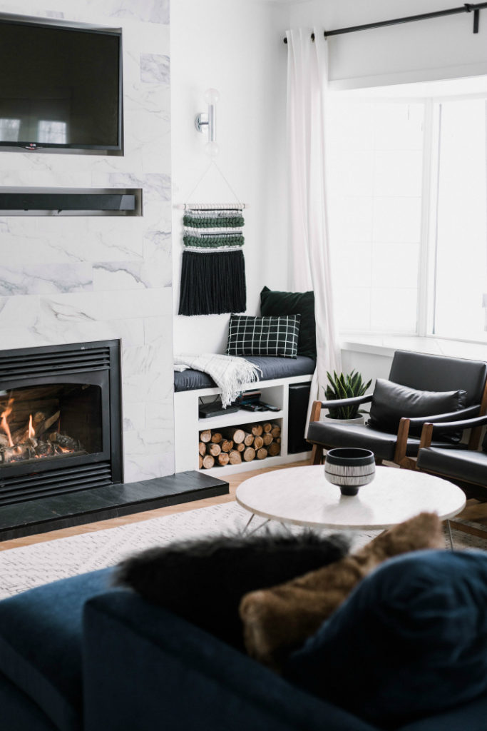 beautiful modern monochrome living room with wood accents and a blue couch