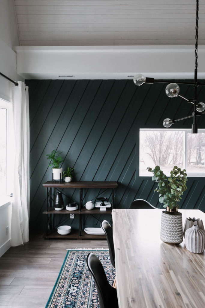 dark accent wall and light table top in modern dining room