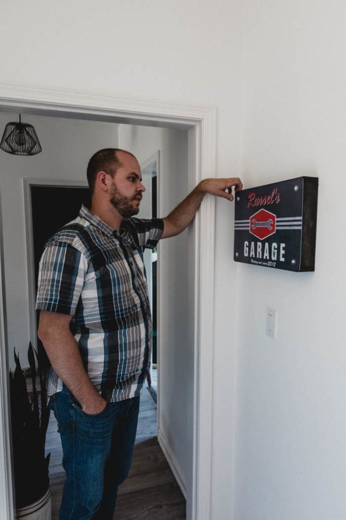 man opening garage sign with hidden storage