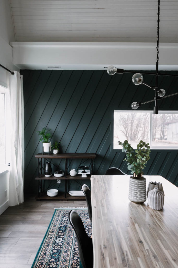 modern dining room with laminate flooring in brown/grey with dark wall