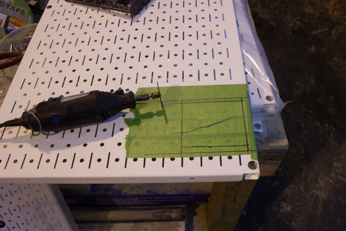 cutting a metal pegboard for installation of an outlet