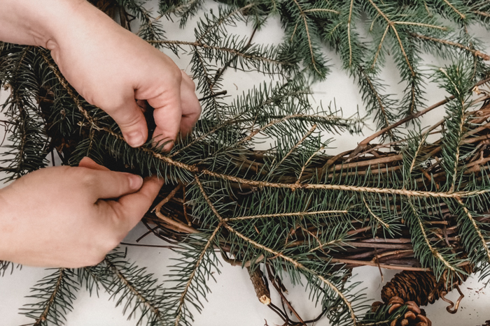 Adding branches to wreath with floral wire