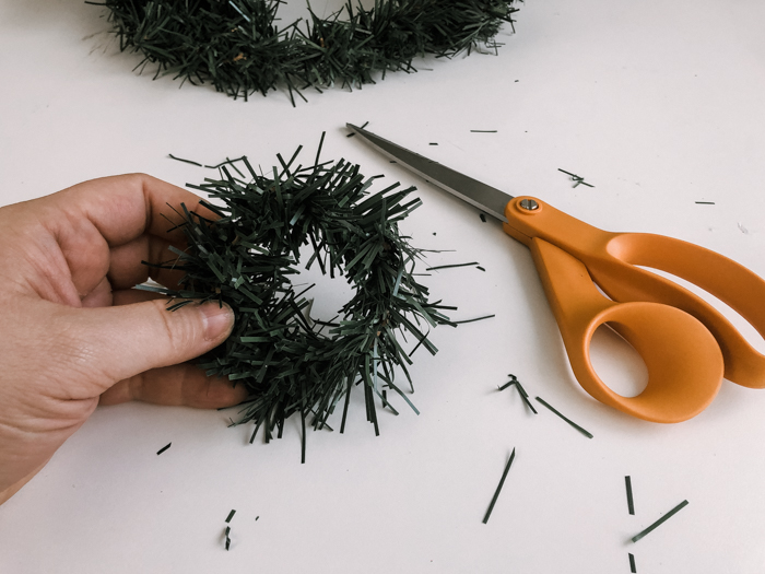 cutting the edges off of a dollar store wreath