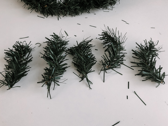 cutting pieces of faux pine wreath